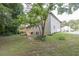 View of the backyard featuring a newly constructed deck, siding, and mature trees at 1111 Fieldgate Rd, Lawrenceville, GA 30044