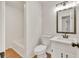 Well-lit bathroom featuring white fixtures, a framed mirror, and a shower tub combo at 1111 Fieldgate Rd, Lawrenceville, GA 30044
