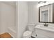 Well-lit bathroom featuring white fixtures, a framed mirror, and a shower tub combo at 1111 Fieldgate Rd, Lawrenceville, GA 30044