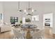 Open concept dining area with a modern chandelier, hardwood floors, and a seamless flow into the living area at 1111 Fieldgate Rd, Lawrenceville, GA 30044