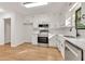 Updated kitchen featuring white cabinets, stainless steel appliances, granite counters, and hardwood flooring at 1111 Fieldgate Rd, Lawrenceville, GA 30044
