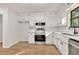 Updated kitchen featuring white cabinets, stainless steel appliances, granite counters, and hardwood flooring at 1111 Fieldgate Rd, Lawrenceville, GA 30044