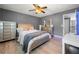 Comfortable bedroom with hardwood floors, neutral walls, ceiling fan, and a mirrored dresser at 143 Monarch Way, Hiram, GA 30141