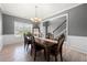 Charming dining area featuring wainscoting, wood floors, decorative chandelier, and bright natural light at 143 Monarch Way, Hiram, GA 30141