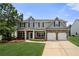 Charming two-story home with a well-manicured lawn, stone accents, and a two-car garage at 143 Monarch Way, Hiram, GA 30141