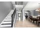 Inviting foyer features a staircase with dark railing, wood floors, and dining area at 143 Monarch Way, Hiram, GA 30141