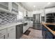 Modern kitchen boasts white cabinetry, stainless steel appliances, and sleek countertops at 143 Monarch Way, Hiram, GA 30141