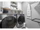 Neat laundry room with new appliances and shelving for organizing detergents and supplies at 143 Monarch Way, Hiram, GA 30141