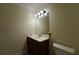 Small powder room featuring a wooden vanity, framed mirror, and toilet at 1601 Haven Crest Ct, Powder Springs, GA 30127