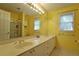 Bright yellow bathroom with double sinks and a glass-enclosed shower at 1601 Haven Crest Ct, Powder Springs, GA 30127