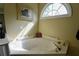An angled view of bathtub area complete with jetted tub and arched window at 1601 Haven Crest Ct, Powder Springs, GA 30127