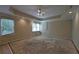 Spacious room with large windows, tray ceiling, ceiling fan and recessed lights awaiting flooring at 1601 Haven Crest Ct, Powder Springs, GA 30127