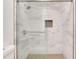 Modern tiled shower featuring a rainfall shower head, built-in niche, and a seamless glass door at 206 Tuxworth Cir, Decatur, GA 30033