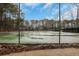 View of fenced community tennis court set amid trees and blue skies at 206 Tuxworth Cir, Decatur, GA 30033