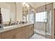 Elegant bathroom features a double sink vanity, a large mirror, and a tiled shower with glass door at 224 Mountain View Dr, Woodstock, GA 30188