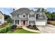 Charming two-story home with gray siding, black shutters, a red door and a well-manicured lawn at 224 Mountain View Dr, Woodstock, GA 30188