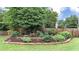 Beautiful landscaping featuring retaining wall, lush green lawn, and a variety of bushes at 224 Mountain View Dr, Woodstock, GA 30188
