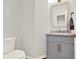 Chic powder room with a gray vanity, marble countertop, and a decorative gold-framed mirror at 224 Mountain View Dr, Woodstock, GA 30188
