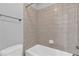 Shower and bathtub combo with neutral tiling and brushed metal fixture at 5865 Trailwood Ct, Suwanee, GA 30024