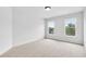 Bedroom featuring two windows offering scenic views, plush carpeting, and modern trim at 5865 Trailwood Ct, Suwanee, GA 30024