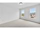 Bright bedroom featuring two windows offering scenic views, plush carpeting, and modern trim at 5865 Trailwood Ct, Suwanee, GA 30024