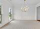 Spacious dining room with a decorative chandelier, large windows and wainscoting at 5865 Trailwood Ct, Suwanee, GA 30024