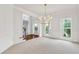Bright dining room featuring a view of the front door entry, large windows and chandelier at 5865 Trailwood Ct, Suwanee, GA 30024