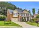 Two-story brick home with beautiful landscaping, manicured lawn and a two car garage at 5865 Trailwood Ct, Suwanee, GA 30024