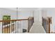 Bright hallway features wrought iron railing overlooking the living room with fireplace and many windows at 5865 Trailwood Ct, Suwanee, GA 30024
