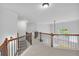 Bright upstairs hallway features white walls, brown wood railing, and access to the bedrooms at 5865 Trailwood Ct, Suwanee, GA 30024