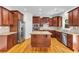 Updated kitchen with stainless steel appliances, granite countertops, a center island, and wood floors at 5865 Trailwood Ct, Suwanee, GA 30024