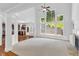 Spacious living room with a fireplace, large windows and a view of the kitchen area at 5865 Trailwood Ct, Suwanee, GA 30024