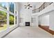 Open living room with fireplace, built-in shelves, and large windows offering a view of the backyard at 5865 Trailwood Ct, Suwanee, GA 30024