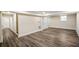 Open basement featuring wood-look flooring, white trim, and a glimpse of a staircase at 1890 Carla Dr, Morrow, GA 30260