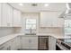 A modern, bright kitchen features white cabinets, stainless steel appliances and stylish countertops at 1890 Carla Dr, Morrow, GA 30260