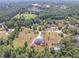 Aerial view of a sprawling estate with a brick home, tennis court, mature trees, and manicured lawns at 2740 Bountiful Pl, Lawrenceville, GA 30045