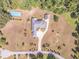 Aerial view of a house with a tennis court, surrounded by mature trees and a long driveway at 2740 Bountiful Pl, Lawrenceville, GA 30045