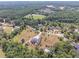 Aerial view of a community with a brick home, tennis court, mature trees, and sprawling lawns at 2740 Bountiful Pl, Lawrenceville, GA 30045