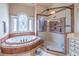 Luxurious bathroom featuring a soaking tub with a stained-glass window and a spacious walk-in shower at 2740 Bountiful Pl, Lawrenceville, GA 30045