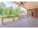 Spacious covered deck featuring a ceiling fan, tile flooring, and a beautiful view of the wooded backyard at 2740 Bountiful Pl, Lawrenceville, GA 30045