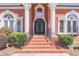Elegant front entrance with brick steps, wrought iron railings, columns, and decorative windows at 2740 Bountiful Pl, Lawrenceville, GA 30045