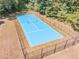 Aerial view of fenced in blue tennis court surrounded by lush landscaping at 2740 Bountiful Pl, Lawrenceville, GA 30045