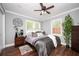 Cozy bedroom featuring modern ceiling fan, with a light, hardwood floors, and natural light from the windows at 3479 Thompson Dr, Atlanta, GA 30331