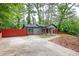 A cozy single-story home with gray siding, a red privacy fence, a covered porch and a long driveway at 3479 Thompson Dr, Atlanta, GA 30331