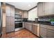 Kitchen featuring stainless steel appliances, dark countertops, and wood floors at 3479 Thompson Dr, Atlanta, GA 30331