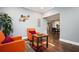 Bright seating area with two orange chairs, hardwood floors, and a view into the dining and kitchen area at 3479 Thompson Dr, Atlanta, GA 30331