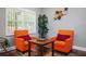 Relaxing seating area with two orange chairs, hardwood floors, and a view into the dining area at 3479 Thompson Dr, Atlanta, GA 30331