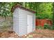 Exterior view of a backyard shed with painted horizontal siding, a simple door, and a shingled roof at 3479 Thompson Dr, Atlanta, GA 30331