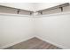 A walk-in closet with silver clothes rods, white trim, and grey wood-look flooring at 523 Mount Zion, Hapeville, GA 30354