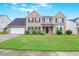 Charming two-story brick home with a well-manicured lawn and classic black shutters at 841 Holly Meadow Dr, Buford, GA 30518